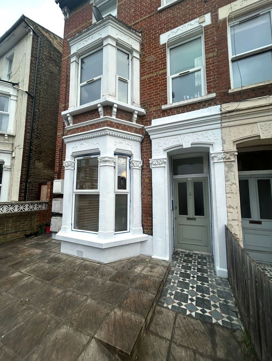 Freshly painted Victorian terrace frontage with a restored tiled path