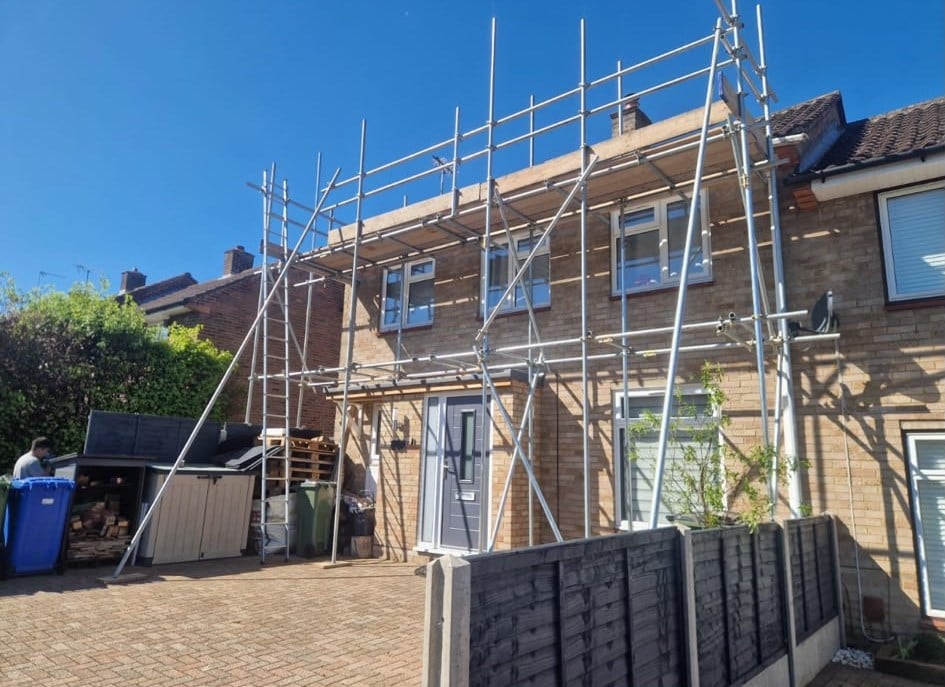 Scaffold on a terraced house under a blue sky ready for roofing works